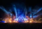 夜の野外音楽フェス会場、ステージ照明とスモークが立ち込める様子のイメージ