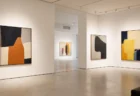 白壁に抽象的な現代アート作品がいくつか並ぶ、明るく静かな展示ギャラリー
