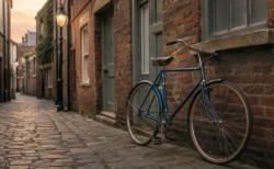 英国の石畳の路地にたたずむクラシックな青いヴィンテージ自転車