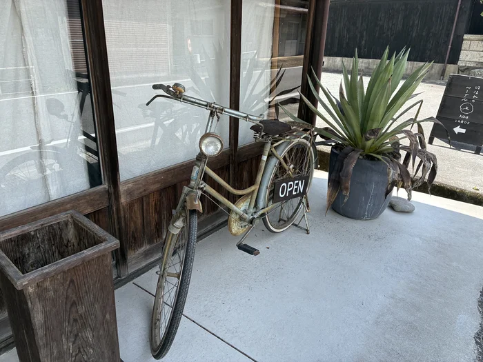 画像 くにす食堂の入口に置かれた古い自転車とOPENサイン