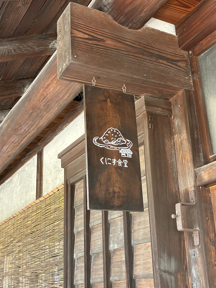 画像 くにす食堂の文字が書かれた木製の店名看板