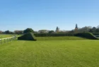 中山競馬場の障害コース、生垣障害（バンケット障害）を望む晴天の情景