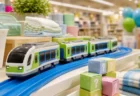 緑と青の車両が走る玩具の線路とタオル、収納用品