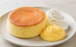 スフレパンケーキにホイップクリームとカスタードクリームを添えた新作スイーツのイメージ