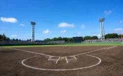 夏の高校野球球場、内野ダイヤモンドと青空、遠景の応援スタンド