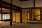 金箔の屏風と畳敷きの書院造りの座敷、障子から差し込む光と床の間の花