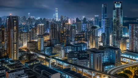ネオンや窓明かりが灯る近未来的なアジアの大都市の夜景、高層ビル群が立ち並ぶ都市風景