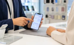携帯ショップでスマートフォンの画面を確認する手元