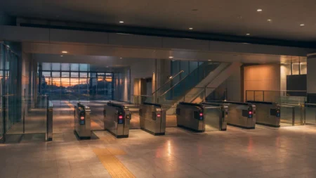 夕方の柔らかい光に包まれた無人の駅改札のイメージ