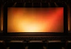 映画館の客席後方から見たスクリーンと照明のイメージ