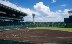 夏の甲子園を象徴する球場スタンドと内野グラウンド、青空のイメージ