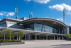 青空の下、大型展示場の外観と通信用アンテナ