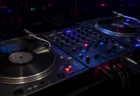 暗いクラブのDJブースに置かれたターンテーブルとミキサー