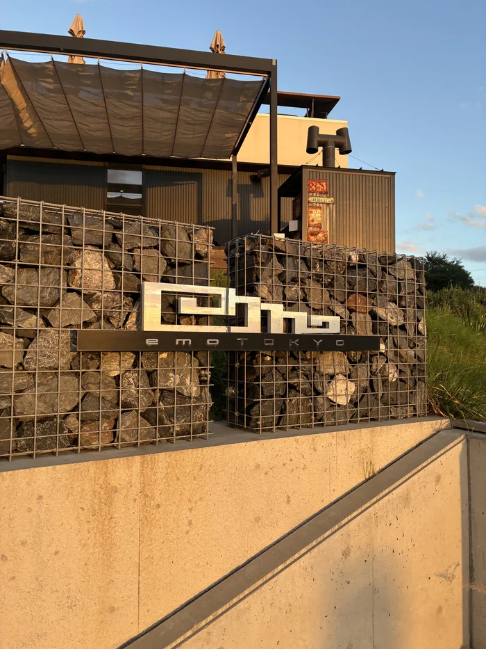 画像 石積みの壁に取り付けられた「emo TOKYO」のロゴ看板
