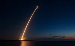 夜明け前の海沿いの発射場から打ち上げられるロケットの光跡のイメージ