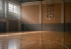 柔らかな光が差し込む無人の屋内バスケットボールコート