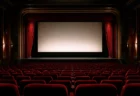 赤いベルベットの座席とカーテンが並ぶ、格式ある映画館の劇場内