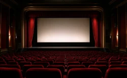 赤いベルベットの座席とカーテンが並ぶ、格式ある映画館の劇場内