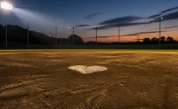 夕方のナイター照明に照らされた高校野球のグラウンドとベース