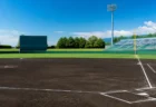 青空の下、内野の黒土と芝が整備された高校野球の球場