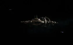 宇宙空間に浮かぶ光の灯ったスペースコロニーの遠景