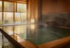 和風温泉施設の内湯、木の縁と湯気の立つお湯