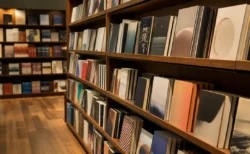 温かい照明の書店で本が斜めに並ぶ棚の情景
