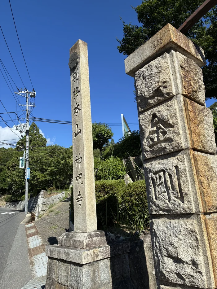 別格本山神呪寺と刻まれた寺号標と金剛の石柱