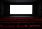 映画館の暗い客席と、前方で白く光るスクリーン