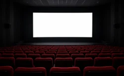 映画館の暗い客席と、前方で白く光るスクリーン