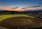 夕暮れの野球場、ナイター照明が灯り始めた無人のグラウンド全景