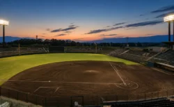 夕暮れの野球場、ナイター照明が灯り始めた無人のグラウンド全景