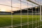 ゴールネット越しに見たサッカーピッチのイメージ