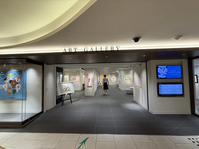 伊勢丹新宿店アートギャラリーの入口と、奥に作品が並ぶ通路