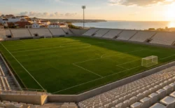 夕暮れの海沿いの町にある無人のサッカースタジアム