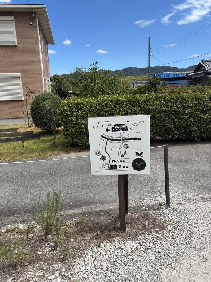 画像 のんきなリスの駐車場に立つ、手描きイラストの案内板