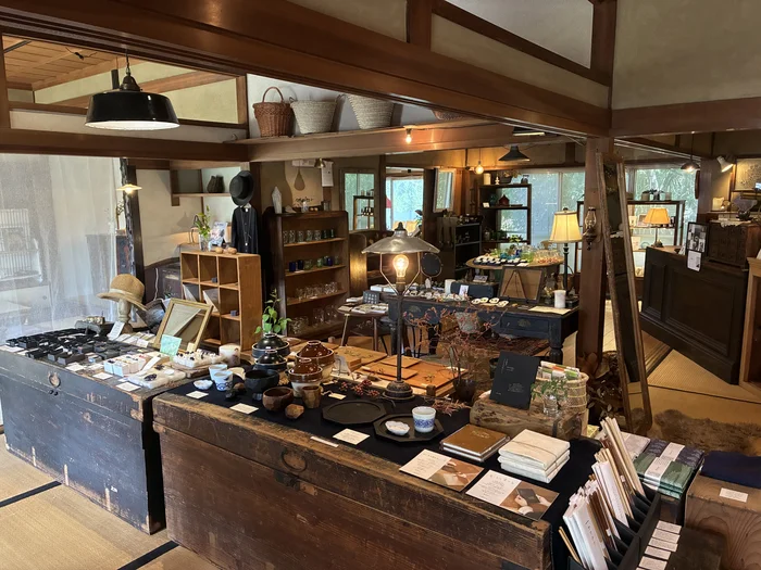 画像 梁がむき出しの天井と、古い箪笥に並ぶ雑貨