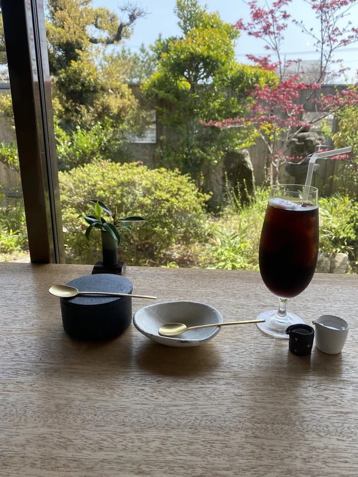 画像 窓辺のカウンターに置かれたアイスコーヒーとプリン