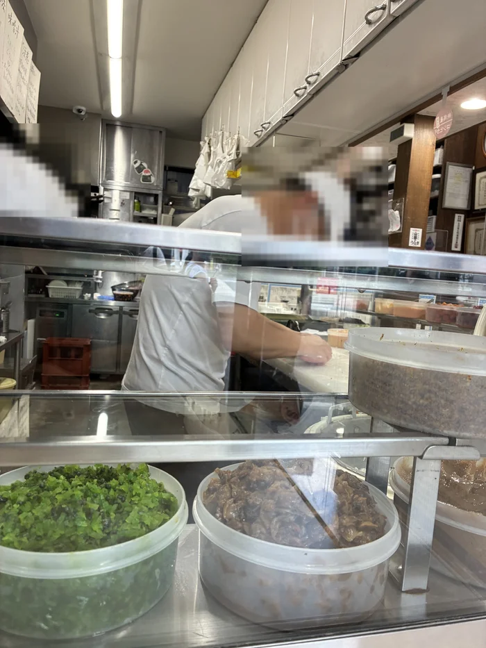 ケースに並んだ具材と、その奥でおにぎりを握る店員