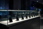 夜のスマートフォンショップのショーケースに並ぶ端末のシルエット