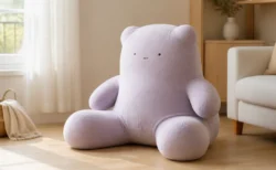 明るいリビングに座る大きな無地のクマ型ぬいぐるみ