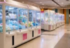 ショッピングセンター内のゲームコーナーに並ぶクレーンゲーム機の写実的な情景