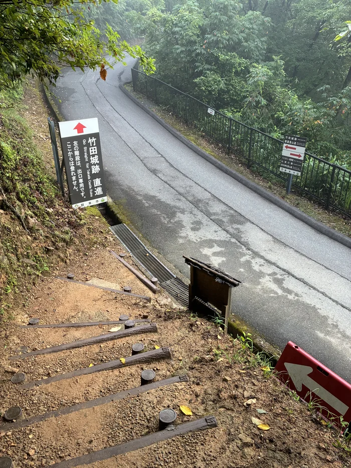 画像 「竹田城跡 直進」と書かれた案内看板と階段
