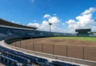 青空の下の高校野球スタジアムのスタンドとグラウンド