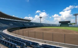 青空の下の高校野球スタジアムのスタンドとグラウンド