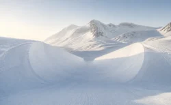 朝の光に照らされた雪山のハーフパイプのイメージ