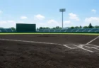 青空の下、内野の黒土と芝が整備された高校野球の球場