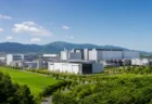 緑豊かな地方の工業団地に広がる工場群と青空