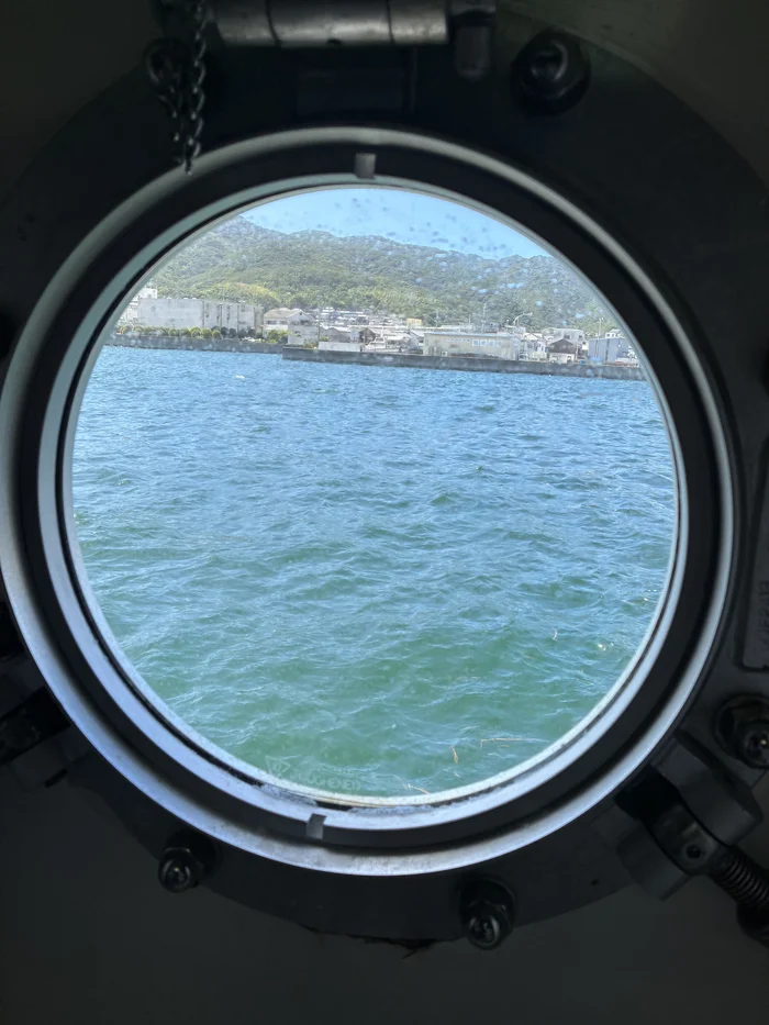 画像 船の丸窓から見える港の町並みと海