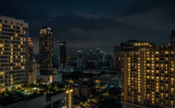 東南アジアの都市の夜景、高層ホテルの窓明かりが立ち並ぶ緊迫感のある情景